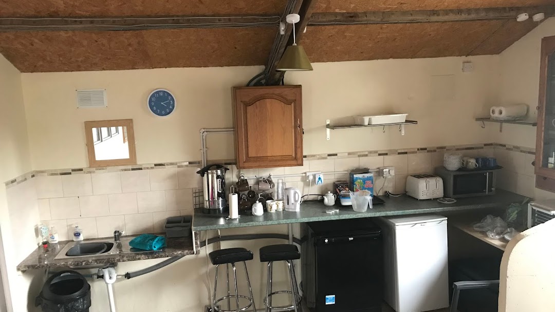 The kitchen in the camping barn, with worktop, stools, fridge and microwave
